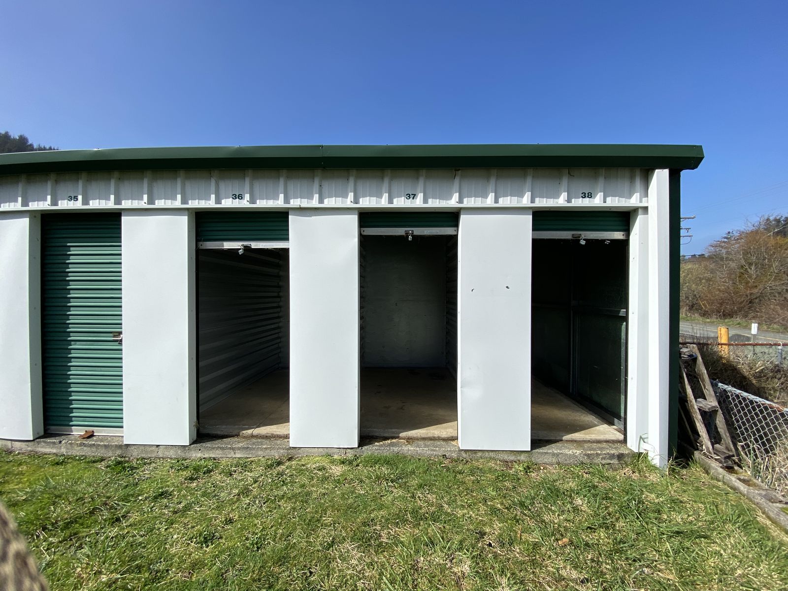 Safety Lock Self Storage building with white walls and green roll-up doors